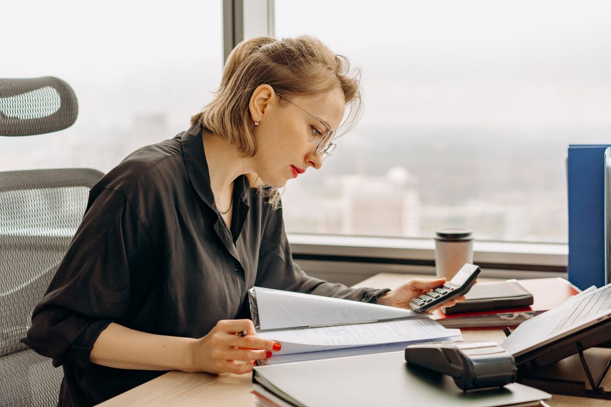 Trabalhadora usando calculadora para conferir verbas trabalhistas